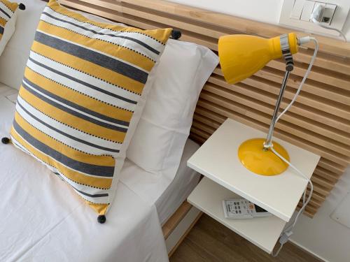 łóżko z poduszką i lampką na stoliku bocznym w obiekcie Appartamento Acquamarina w mieście San Benedetto del Tronto