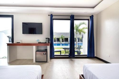 a hotel room with two beds and a view of a pool at OHANA, Panglao Resort. in Panglao Island