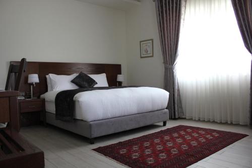 um quarto com uma cama e uma grande janela em Lavender Boutique Hotel em Ramala