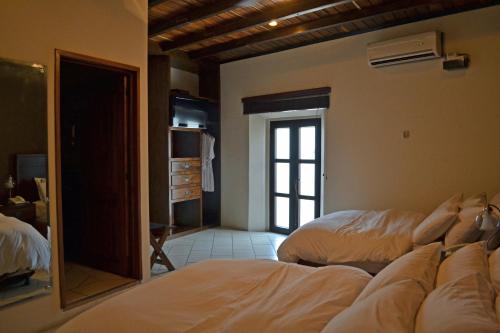 a bedroom with two beds and a mirror at Hotel Posada de Don José in Retalhuleu