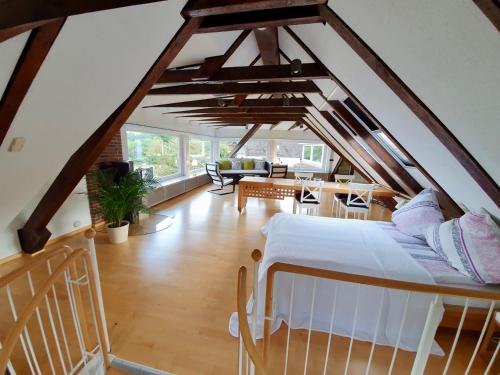 Schlafzimmer im Dachgeschoss mit einem Bett und einem Wohnzimmer in der Unterkunft Ferienwohnung im Auetal - Wohnung I in Hanstedt
