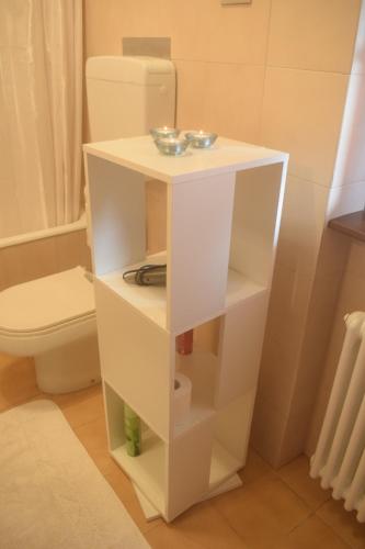 biała półka obok toalety w łazience w obiekcie Landscapesilvia 1 Aria w mieście Menaggio