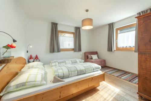 1 dormitorio con 1 cama y 1 silla en Ferienbauernhof Wieserhof, en Fiè