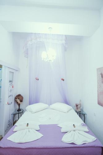 a bedroom with a bed with white sheets and pillows at Studio Lefaki in Rethymno Town