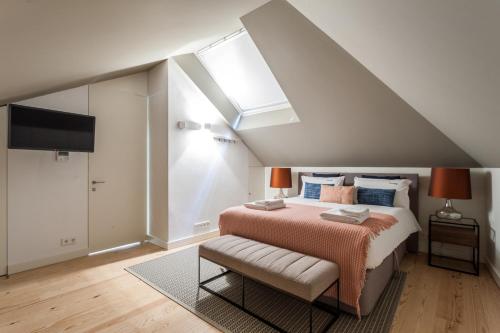 a bedroom with a large bed and a skylight at FLH Bairro Alto Design Flat in Lisbon