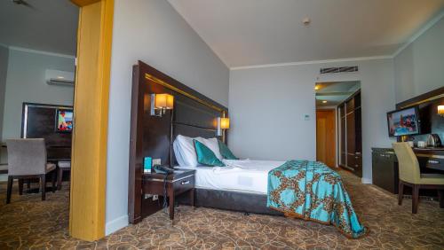 Un pat sau paturi într-o cameră la Grand Belish Hotel