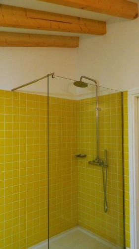 a bathroom with a shower with yellow tile at Quinta Lamosa Agroturismo in Arcos de Valdevez