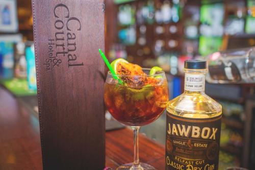 a drink in a glass next to a bottle of whiskey at Canal Court in Newry