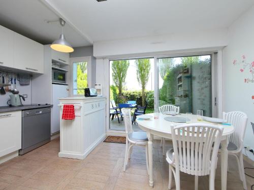 een keuken en eetkamer met een tafel en stoelen bij Apartment Le Garden by Interhome in Cabourg