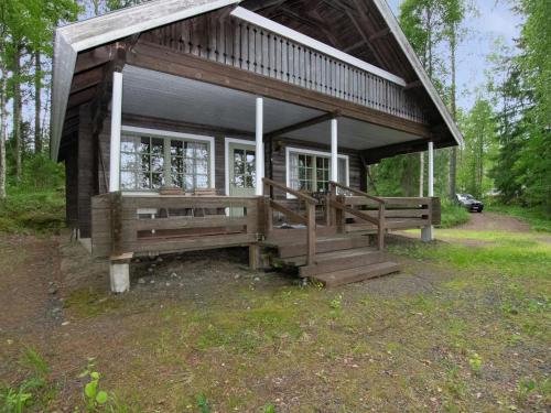 a small cabin in the woods with a porch at Holiday Home Laitamökki by Interhome in Tasapää