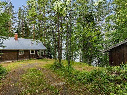 a log cabin in the woods next to a house at Holiday Home Keskimökki by Interhome in Tasapää