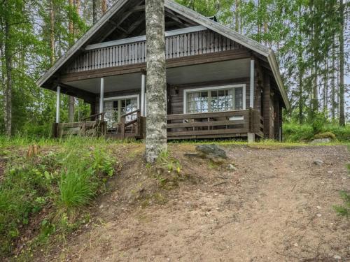 una cabaña de madera en el bosque con un árbol en Holiday Home Laitamökki by Interhome, en Tasapää