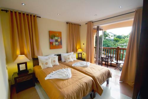 A bed or beds in a room at The Palm Seychelles