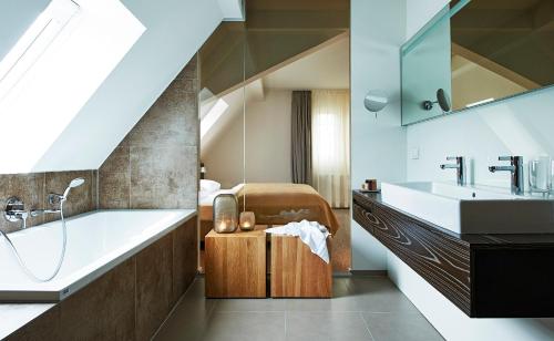 a bathroom with a bath tub and a sink at Weinhaus Henninger in Kallstadt