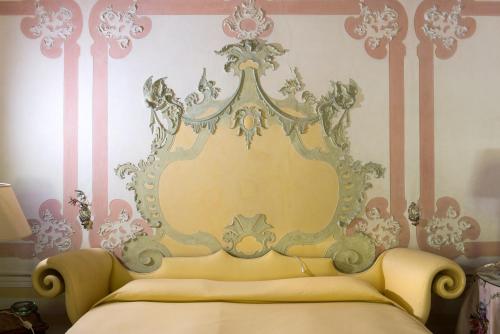 a bedroom with a bed with a fancy headboard at Villa il Galero in Asolo