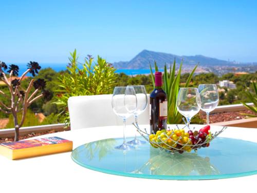 una mesa con tres copas de vino y un tazón de fruta en Apartment Altea La Nova-10 by Interhome, en Bernia