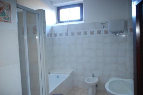 a white bathroom with a toilet and a sink at Agriturismo Le Volte in Mocaiana