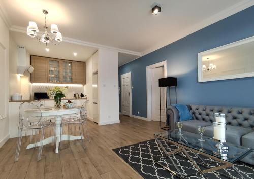 a living room with a couch and a table at Prestige Apartment Słupsk in Słupsk