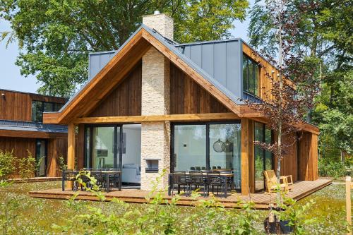 a house with glass doors on a deck at Bergvliet Villa's in Oosterhout