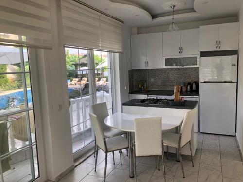 a kitchen with a table and chairs and a refrigerator at BELKA GOLF RESİDENCE Deluxe apt Poolside BELEK in Belek