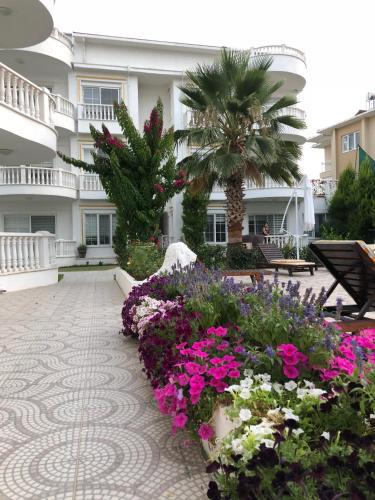 a courtyard with flowers in front of a building at BELKA GOLF RESİDENCE Deluxe apt Poolside BELEK in Belek