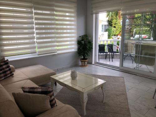 a living room with a couch and a table at BELKA GOLF RESİDENCE Deluxe apt Poolside BELEK in Belek