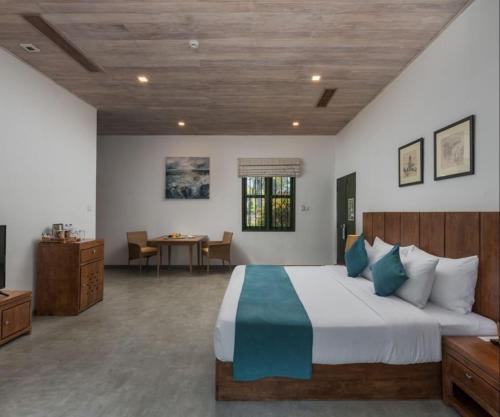 a large bedroom with a large bed and a desk at Regenta Arie Lagoon Negombo in Negombo
