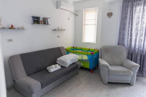 a living room with a couch and a chair at Studio Apartment in Chiajna