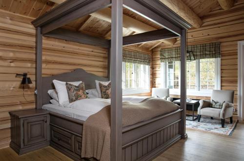 a bedroom with a canopy bed in a log cabin at Storfjord Hotel in Skodje