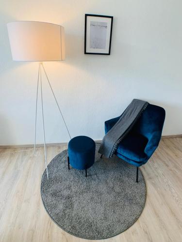 a blue chair sitting on a rug next to a lamp at Komfortables Apartment in Bad Elster mit Netflix in Bad Elster
