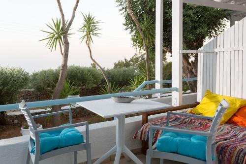 a porch with a table and chairs and a view of the ocean at Ferma Hill Apartments in Ferma