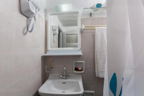 a bathroom with a sink and a mirror at Ferma Hill Apartments in Ferma