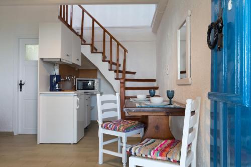 a kitchen with a table and chairs and a staircase at Ferma Hill Apartments in Ferma