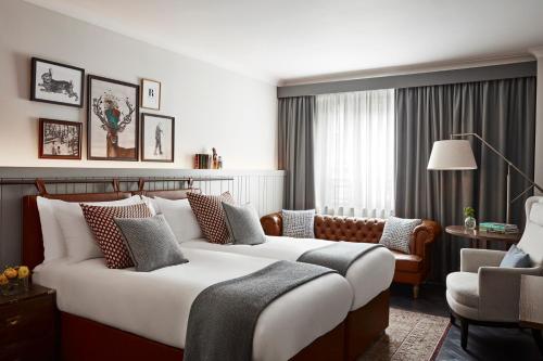 a bedroom with a large bed and a living room at Kimpton Charlotte Square by IHG in Edinburgh