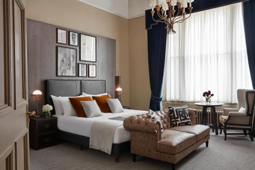 a bedroom with a bed and a couch and a chair at Kimpton Charlotte Square by IHG in Edinburgh