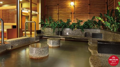 a pool of water in a lobby with plants at Radium Kagaya Taipei in Taipei
