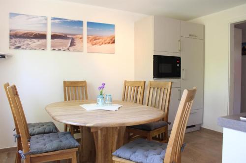 een keuken en eetkamer met een houten tafel en stoelen bij Ferienhaus Wiedingharde II in Tating