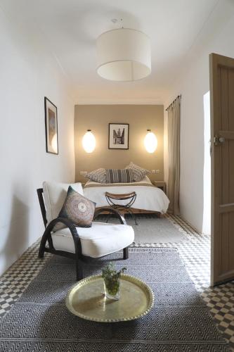 a bedroom with a bed and a couch and a table at Le Petit Hôtel du Flouka in Lalla Takerkoust