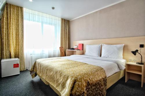 um quarto de hotel com uma cama grande e uma janela em AZIMUT Hotel Astrakhan em Astrakhan