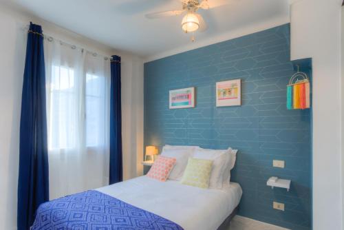 - une chambre avec un mur bleu et un lit dans l'établissement #23 Henry IV Vue Panoramique Mer AC & Bright, à Nice