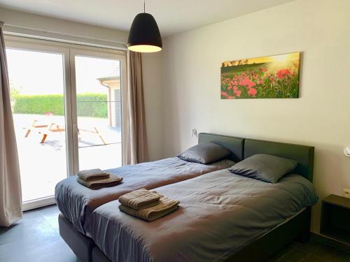 a bedroom with two beds and a large window at Vakantiewoning Ter Luyghem in Houthulst
