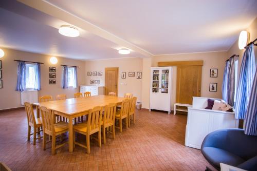 a dining room with a wooden table and chairs at Resort Malevil in Jablonné v Podještědí