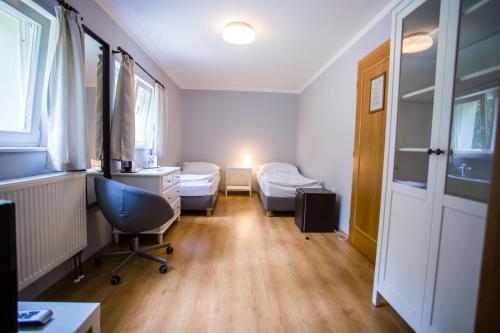 a room with two beds and a desk and a chair at Resort Malevil in Jablonné v Podještědí