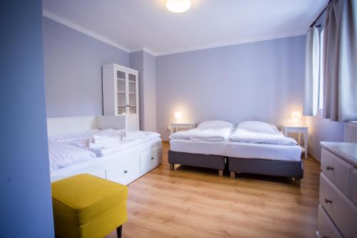 a bedroom with two beds and a yellow stool at Resort Malevil in Jablonné v Podještědí