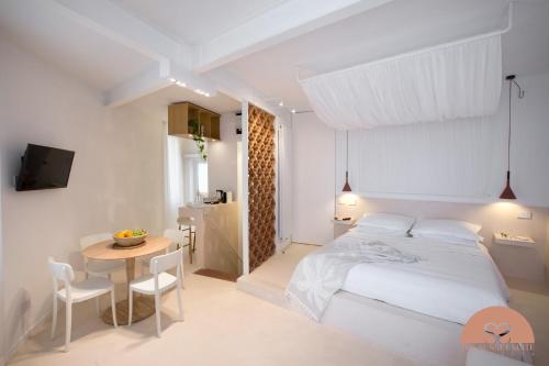 a white bedroom with a bed and a table at The Sunset Suite Vernazza in Vernazza
