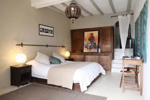 a bedroom with a bed and a television in it at Le Petit Hôtel du Flouka in Lalla Takerkoust