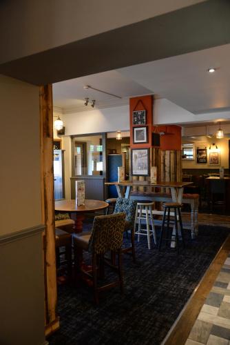 a dining room with tables and chairs and a bar at Southern Cross in Watford