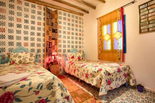 a bedroom with two beds and a window at Afra House in Chefchaouene