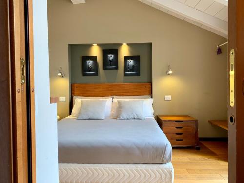 a bedroom with a large bed and two pictures on the wall at Porta Ronca - B&B, Suites & Apts in Rho