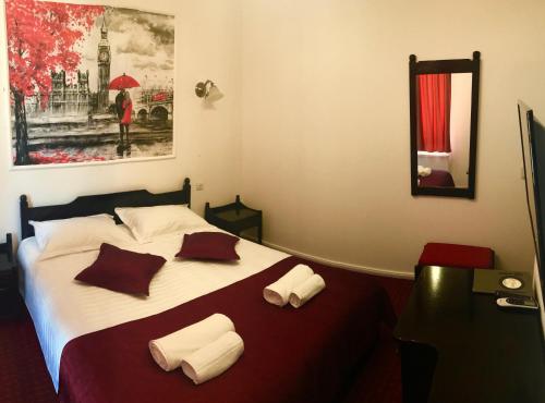 Schlafzimmer mit einem Bett mit roten und weißen Kissen in der Unterkunft Pensiunea Maria in Roşiori de Vede